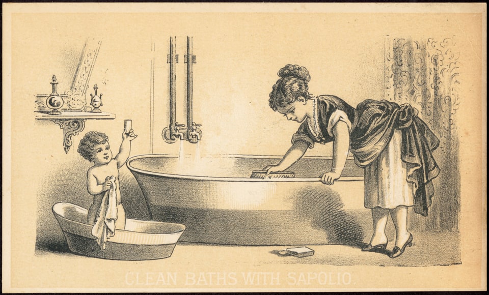 Trade card. A woman in a dress with her sleeves pushed back leans over a large bathtub, scrubbing the inside with a brush while water runs from two taps. To the left, a naked toddler stands in a small oval hip-bath holding a towel and raising a cake of soap. A shelf of bottles and a mirror hang on the wall behind. White lettering across the foot of the card reads “Clean baths with Sapolio.”
